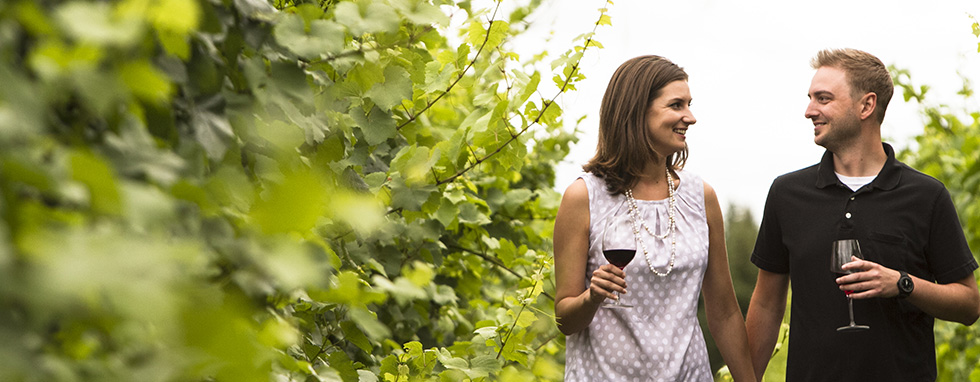 Happy couple strolling through vineyard